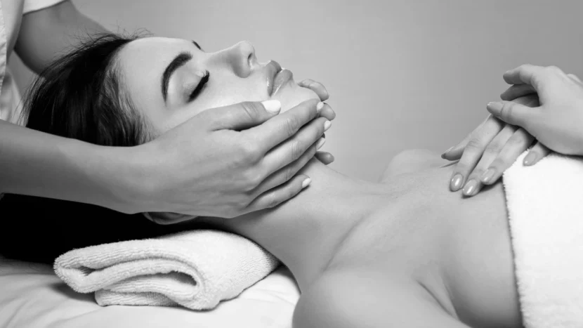 Imagen de una mujer tumbada de forma relajada mientras recibe un tratamiento de rejuvenecimiento facial